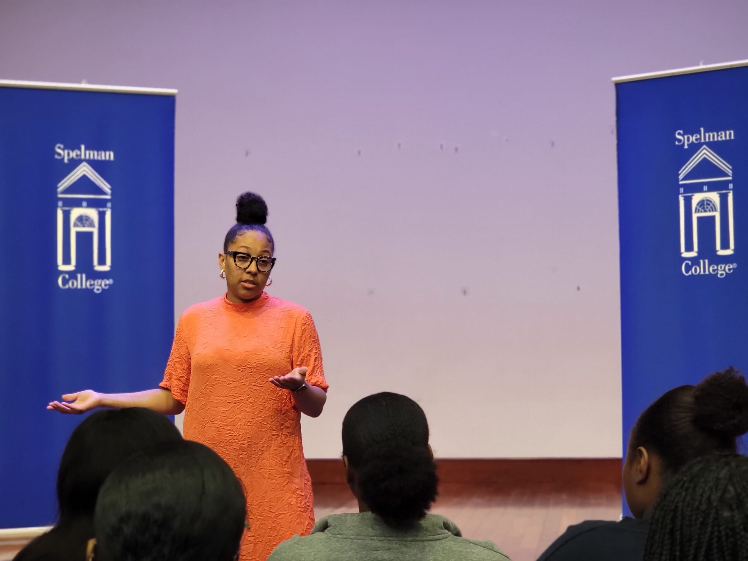 A woman giving a presentation in front of a group of people.