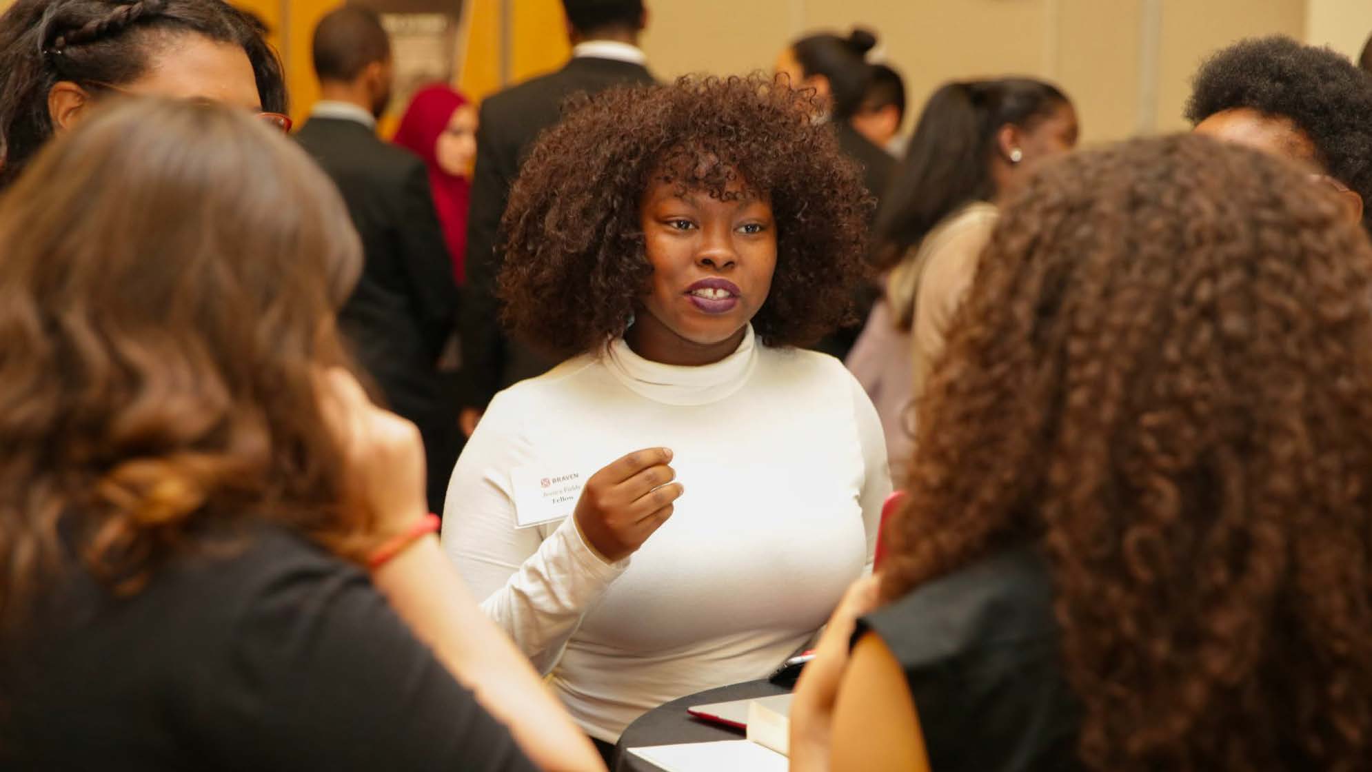 A woman talking to a group of people at an event.