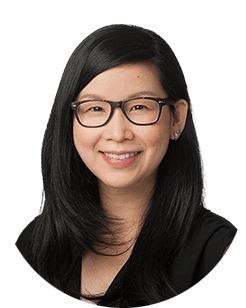 An asian woman wearing glasses and a black shirt.