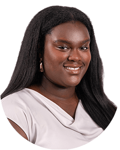 Portrait of a smiling young woman with long dark hair, wearing gold earrings and a white blouse.