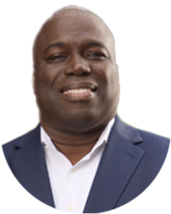 A smiling man wearing a navy blue blazer and white collared shirt.