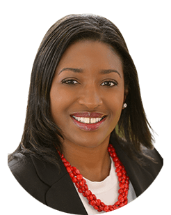 A black woman smiling with a red necklace.