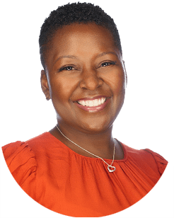 Portrait of a person smiling, wearing a red shirt and a heart-shaped necklace, against a white background.