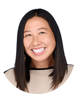 A smiling asian woman in a beige shirt.