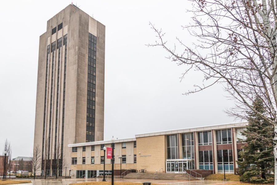 A large building with a clock tower in front of it.