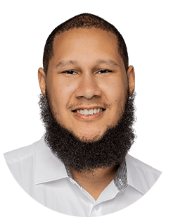 A man with a beard smiling in a white shirt.