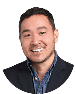 An asian man smiling in a circle.