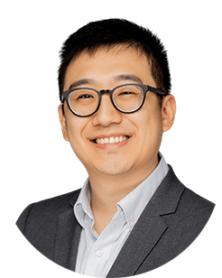 An asian man wearing glasses and a suit.