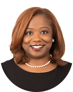 A black woman smiling in a black top.