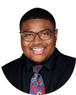 A black man wearing glasses and a tie.