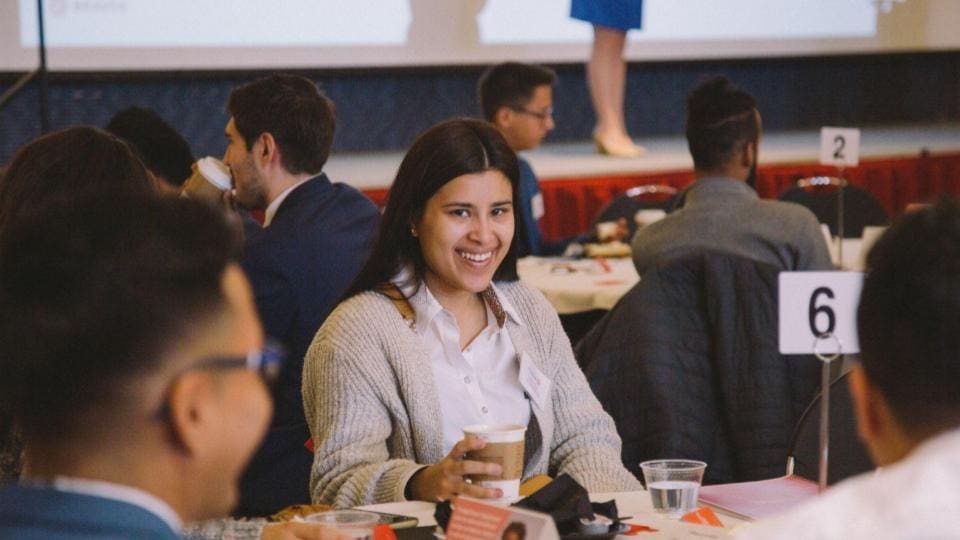 A group of people sitting at a table at an event.