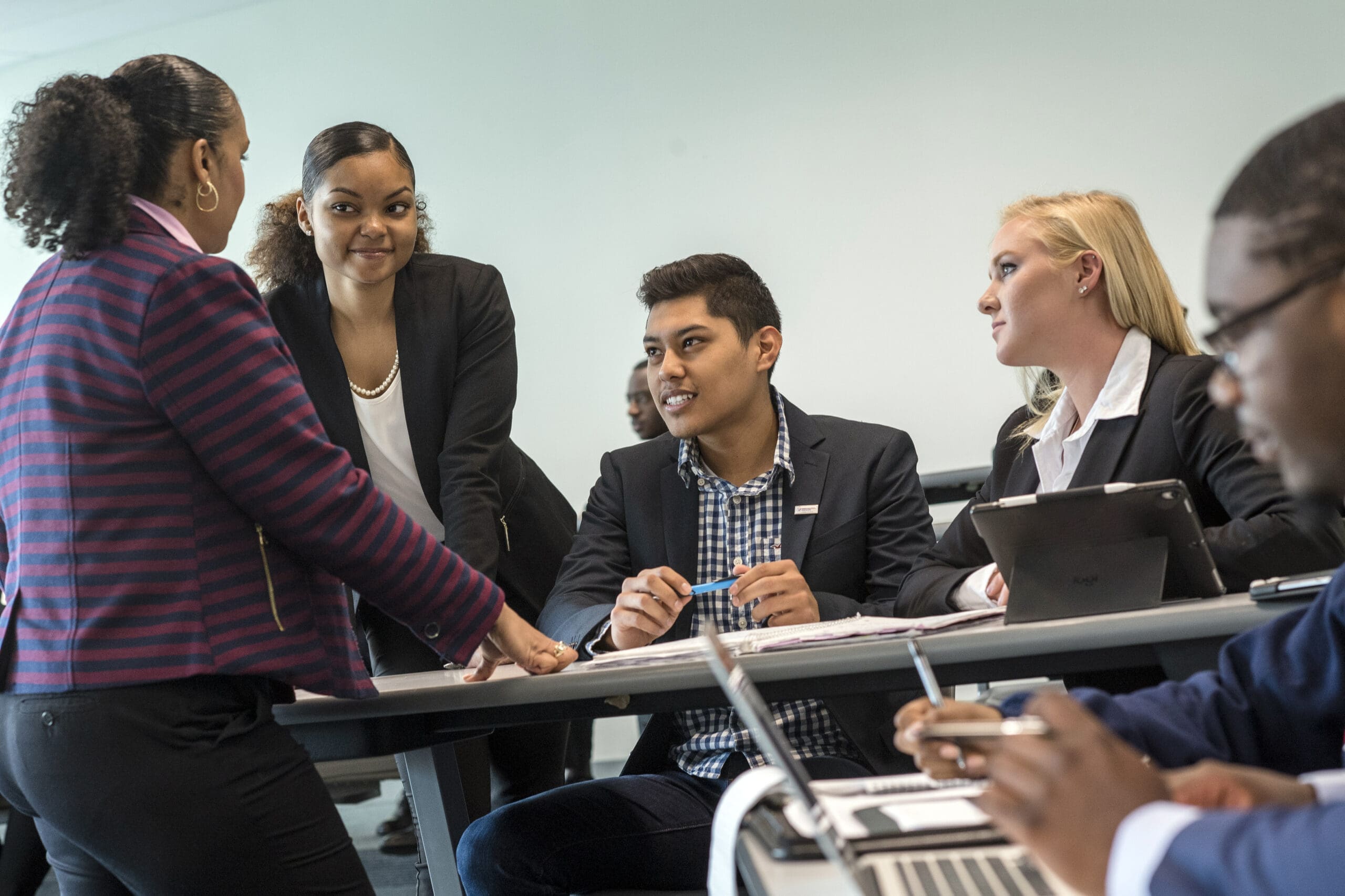 A group of people sitting around a table in a conference room.