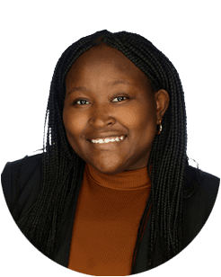 Smiling person with braided hair wearing a brown top and black jacket, posed against a plain white background.