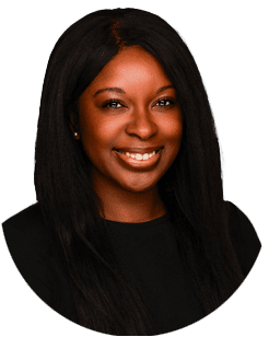 A woman with long straight black hair wearing a black top smiles at the camera against a plain white background.