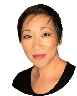 Portrait of a person with short dark hair, wearing a black top, smiling softly. Plain white background.