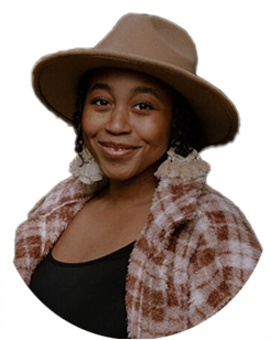 A woman wearing a brown hat, large earrings, a black top, and a plaid jacket, smiling at the camera.