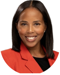 Woman with straight black hair in a red blazer and black shirt, smiling at the camera against a plain background.