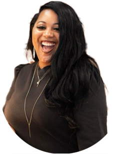 Woman with long black hair wearing a black top, layered necklaces, and earrings, smiling broadly against a plain white background.