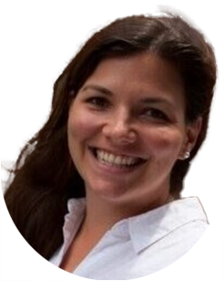 Woman with long dark hair smiling, wearing a white collared shirt, photographed against a plain light background.