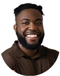 Smiling man with short hair and a beard, wearing a brown collared shirt, against a plain light background.