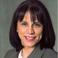 Headshot of a middle-aged woman with dark hair wearing a gray blazer.