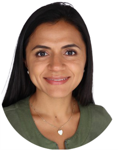 A woman with dark hair smiling at the camera, wearing a green top and a heart-shaped necklace.
